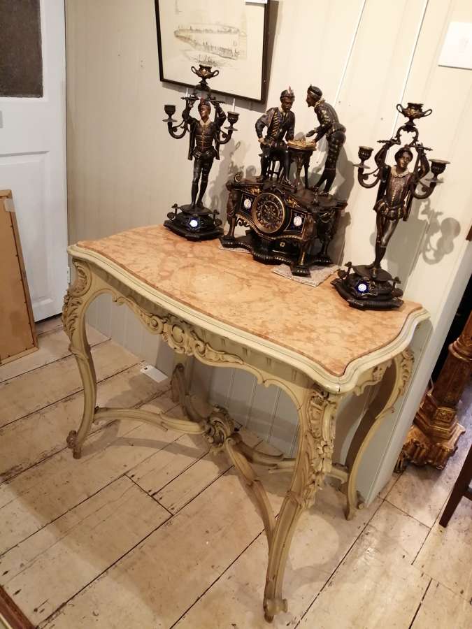 Inside Mere Antiques, Topsham, showing a Louis XV painted console with figural candelabra and a gilt-bronze mantel clock